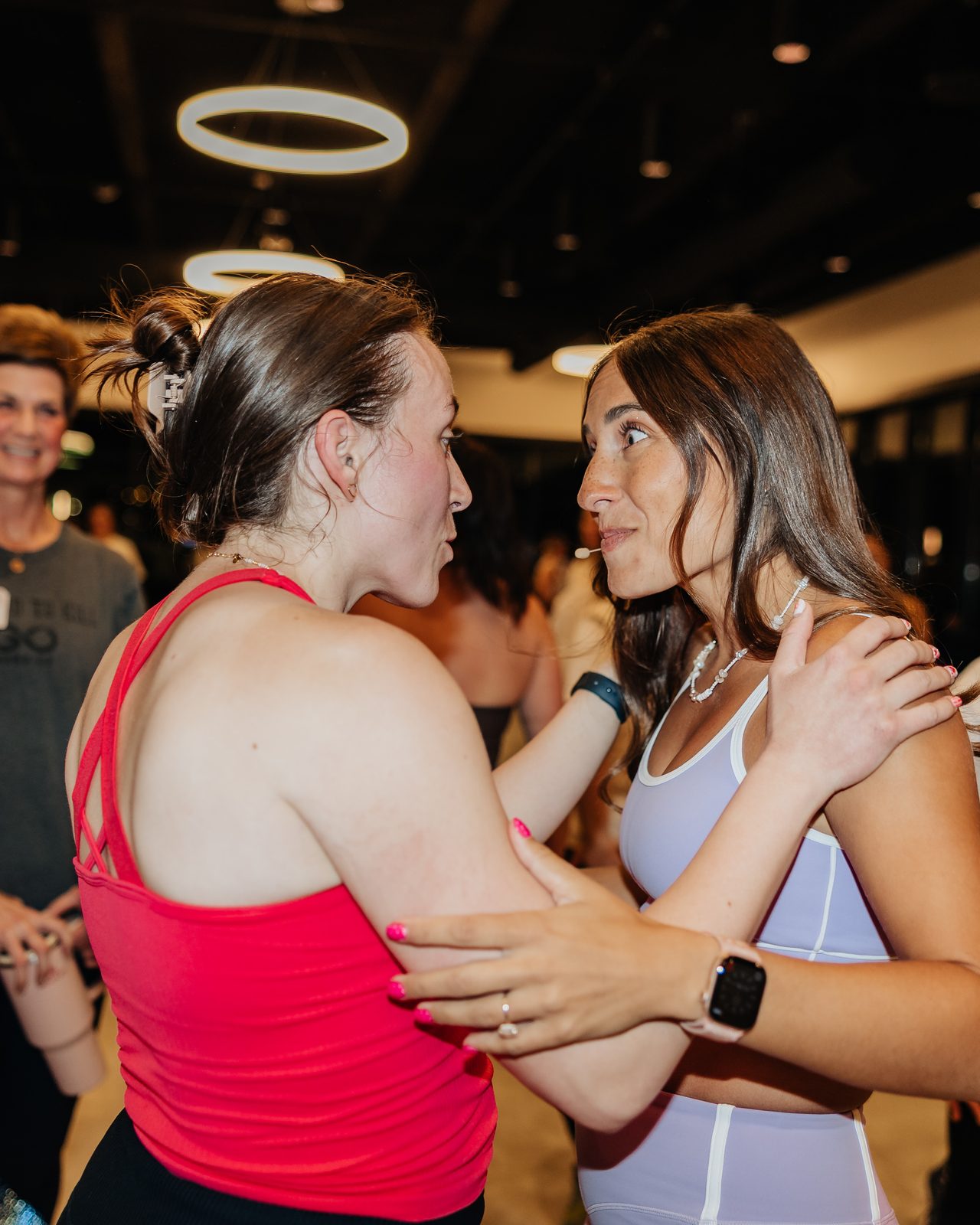 Two Mamele members holding on to each other and talking at an event.